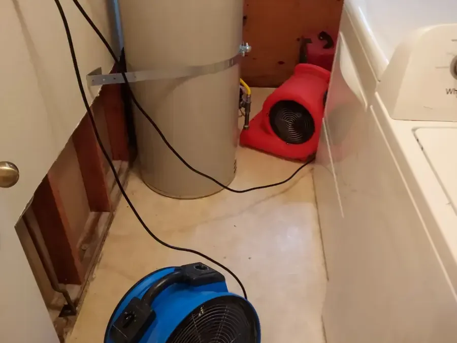 Air movers drying a laundry area with the wall opened behind the washer